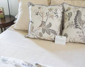 Upclose of the flora pillows on the tan bedspread